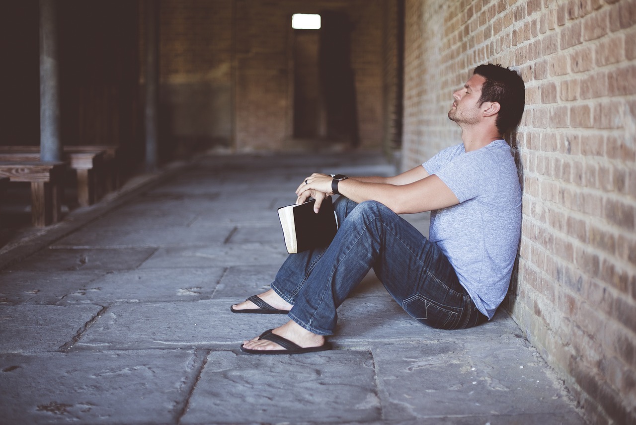 alone book brick wall man person